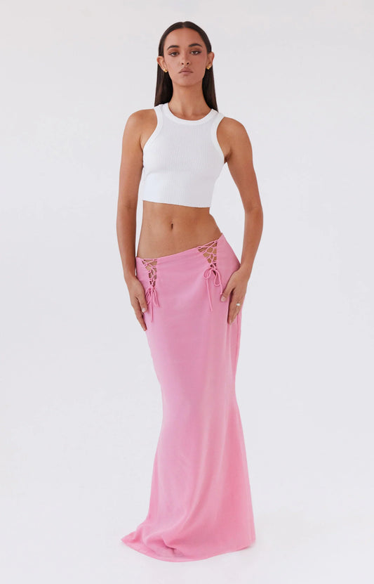 A woman wearing white top and pink skirt from Peppermayo's women's bottoms collection